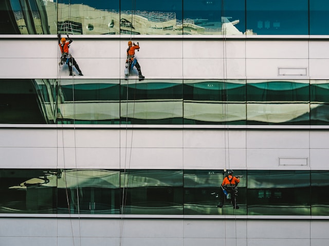 People cleaning the glass windows of a building
